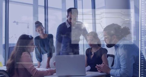 Multiracial team collaborating over laptop with data overlay in modern glass boardroom