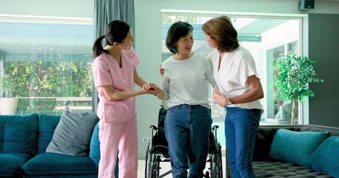 Senior Woman Bonding with Caregiver and Friend at Home