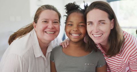 Smiling Lesbian Couple with African American Daughter at Home