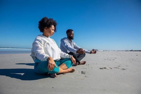 Couple Meditating on Tranquil Sandy Beach