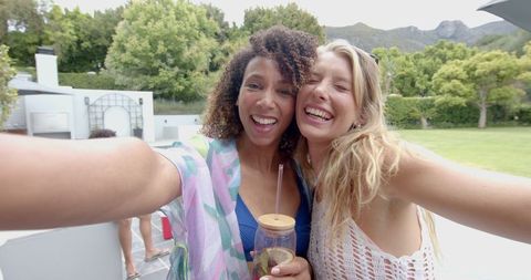 Joyful Friends Taking Selfie at Outdoor Party with Scenic Mountains