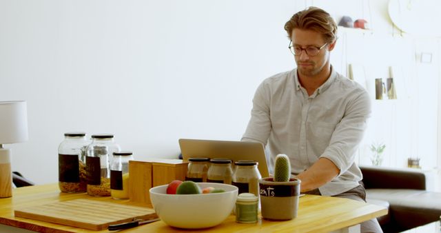 Man Working Remotely from Home, Surrounded by Office Supplies and Personal Items - Download Free Stock Images Pikwizard.com