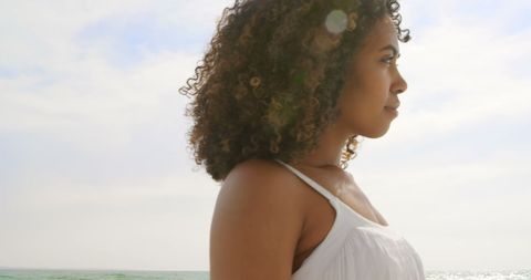 Peaceful Beach Stroll: Side View of Smiling Woman in Sunlight