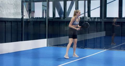 Female Athlete Preparing Padel Swing on Blue Court