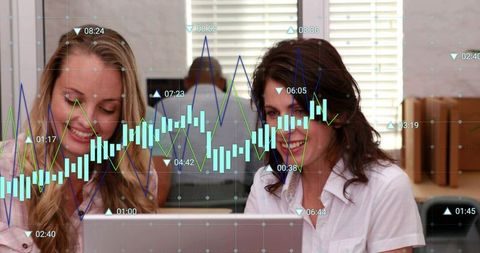 Colleagues Collaborating Over Laptop Showing Financial Candlestick Chart Overlay