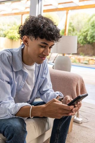 Young Man Engaged with Smartphone in Cozy Living Room