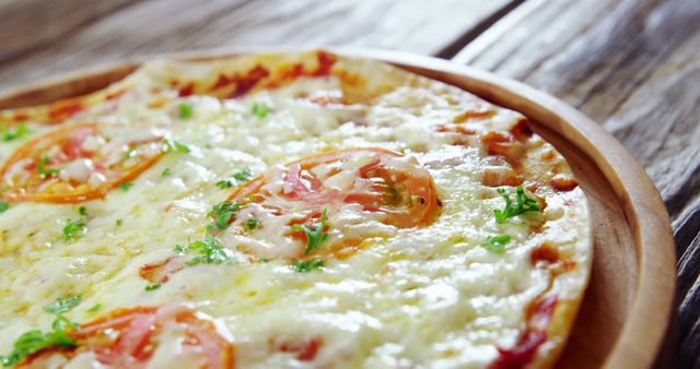 Close-up of a freshly baked Margherita pizza topped with melted cheese, tomato slices, and parsley, served on a wooden plate. Suitable for use in food blogs, restaurant menus, pizzeria marketing materials, and culinary websites.