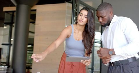 Diverse Team Discussing Project Using Tablet in Modern Office