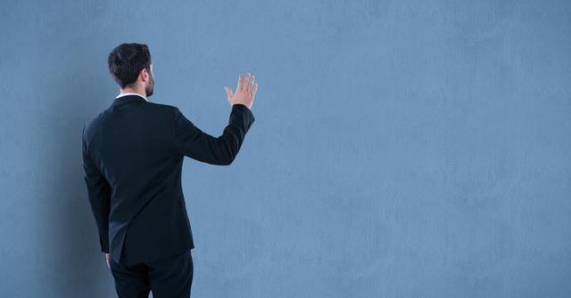 Businessman gesturing at blank wall suggests possibilities for presentations, planning, or generating ideas. Useful for business-related themes, promotions, or conceptual illustrations.