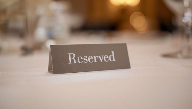 Reserved Table Card on Elegant Banquet Table with Bokeh Candlelight and Glassware