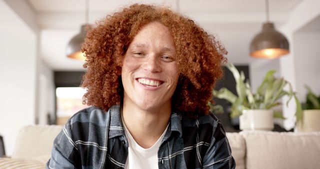 Portrait of smiling young man with curly red hair indoors - Download Free Stock Images Pikwizard.com