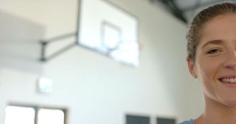 Confident Female Athlete with Basketball Hoop Focused on Success