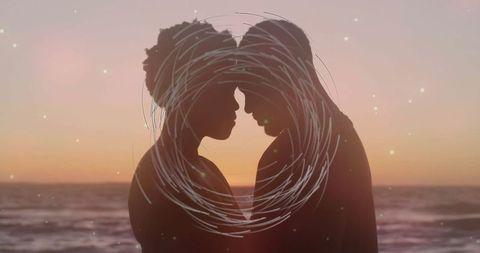 Romantic silhouette of couple embracing on scenic beach at sunset