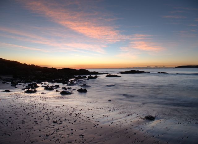 Tranquil Coastal Sunset with Pink Clouds and Rocks - Download Free Stock Photos Pikwizard.com