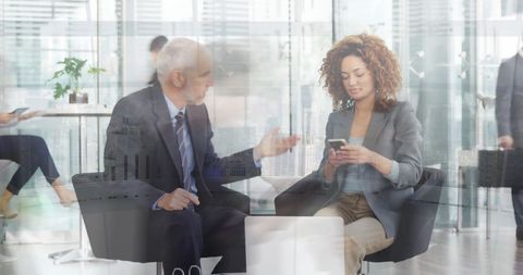 African American Woman Using Smartphone During Business Meeting with Senior Colleague