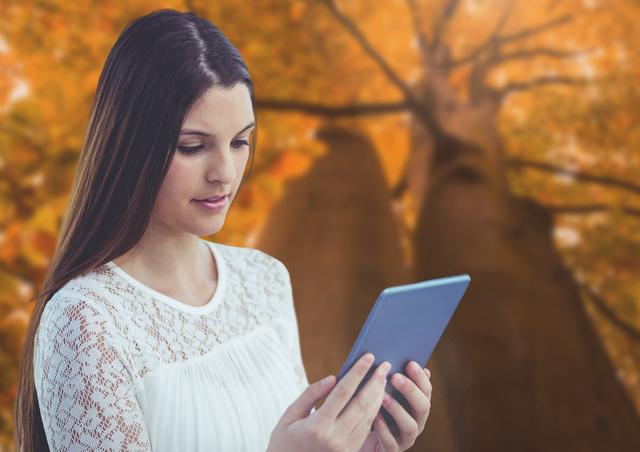 Young Woman Using Tablet with Autumn Forest Background - Download Free Stock Photos Pikwizard.com