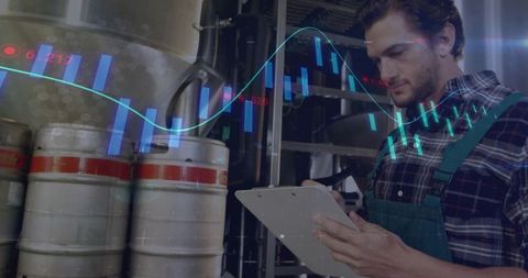 Brewery worker analyzing real-time production data with digital charts