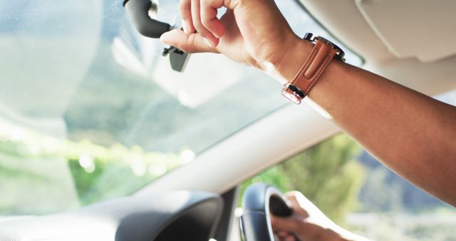 Person Adjusting Rearview Mirror in Car Interior with Greenery Outside - Download Free Stock Images Pikwizard.com