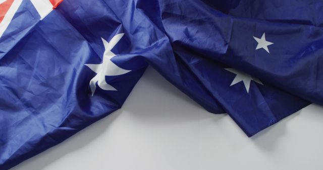 Image of creased flag of australia lying on white background. nationality, state symbols, patriotism and independence concept.