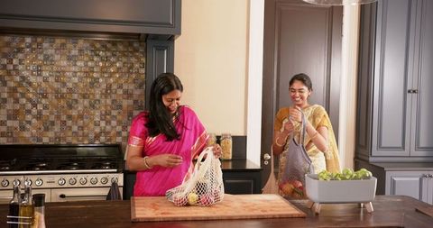Two Women Unpacking Groceries in Modern Kitchen Setting