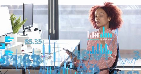 Businesswoman reviewing analytics on tablet at workstation with overlaid data visualizations