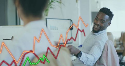 Smiling black man collaborating on analytics with colorful growth charts in modern office