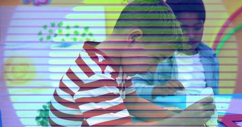 Young boy drawing in colorful classroom with tablet and mural, creative learning