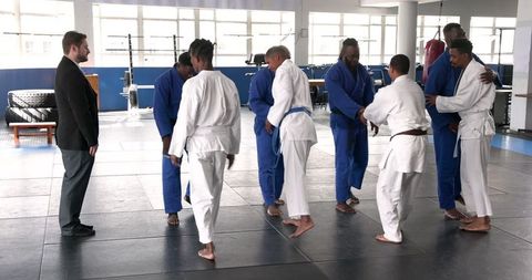Judo Students Practicing Kicks with Instructor Observing Training