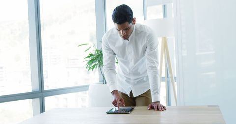Executive engaging with digital tablet in bright office