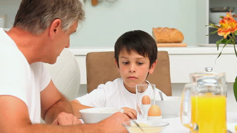 Father and Son Having Breakfast Together in Kitchen