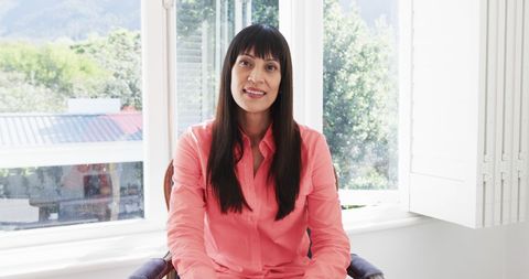 Joyful Biracial Woman in Bright Room Smiling at Camera