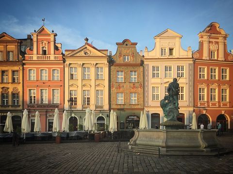 Colorful Old Town Facades Featuring Ornate Fountain and Cobblestone Square at Sunset