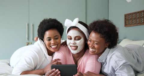 African american women relaxing with self-care watching tablet
