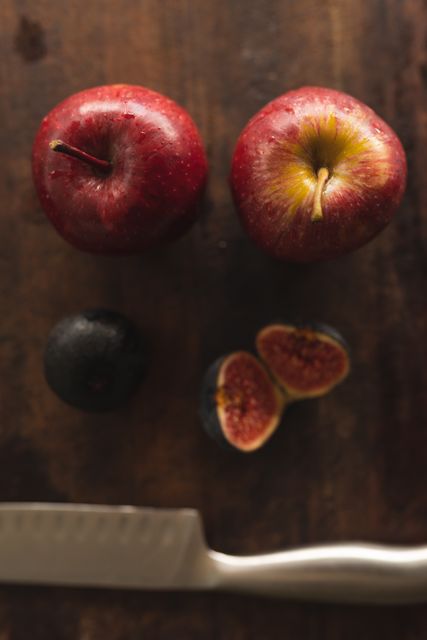 High angle close up of two apples, plum and fig on wooden surface. Fresh fruit healthy eating source of Vitamin C.
