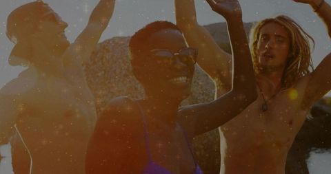 Friends Celebrating at Rocky Shore During Sunset