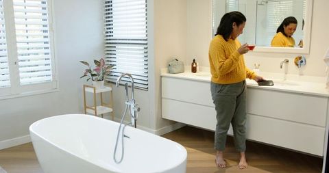 Modern Minimalist Bathroom with Woman and Freestanding Tub
