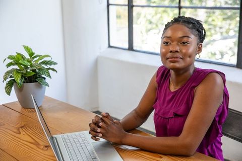 Confident Professional Woman in Home Office with Laptop