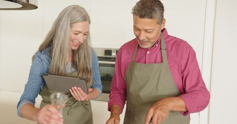 Happy Mature Couple Cooking Together in Modern Kitchen