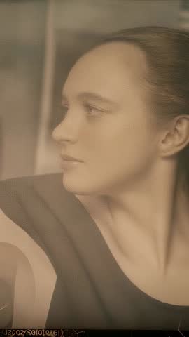 Vertical video showing woman adjusting head pose in private studio, contemplative portrait