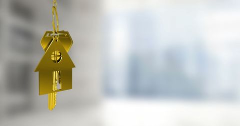 Golden Keychain in Shape of House, Representing Real Estate and Home Ownership