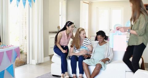 Diverse Group of Women Celebrating Baby Shower with Gifts in Living Room