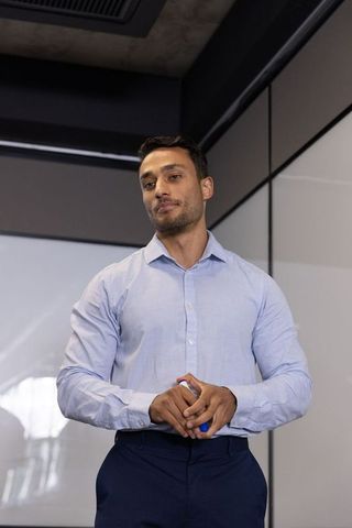 Professional businessman prepares for presentation on glass board in office