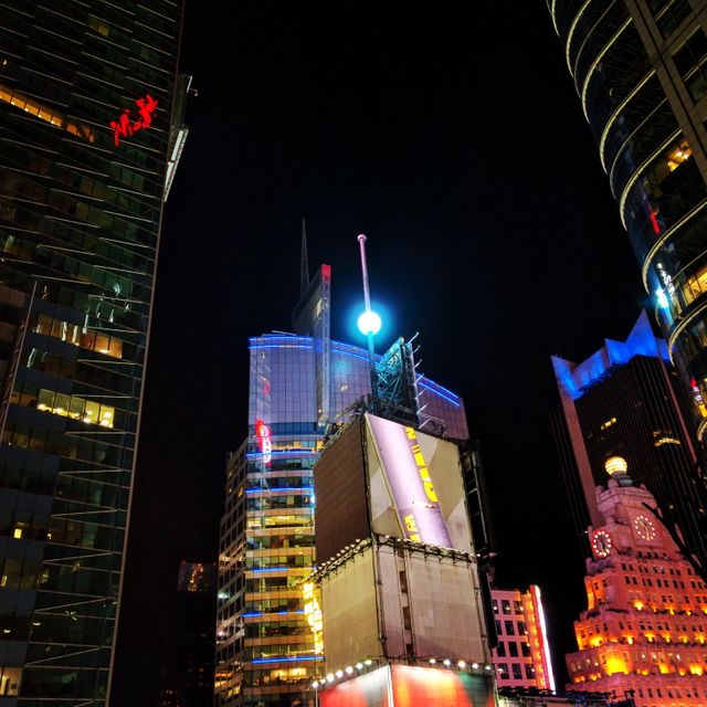 Dynamic night scene of Times Square in New York City features brightly illuminated skyscrapers and vibrant advertising screens. Ideal for use in tourism promotions, urban lifestyle articles, advertising themes, and architectural showcases. The image captures the energetic atmosphere and highlights the iconic neon lights and modern cityscape that attract visitors from around the world.