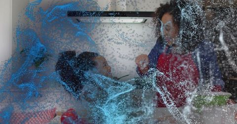 Mother and Daughter Sharing Snack at Kitchen Counter with Blue Particle Overlay and Greens