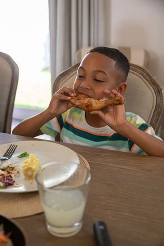 Boy Enjoying Meal at Home Dining Table