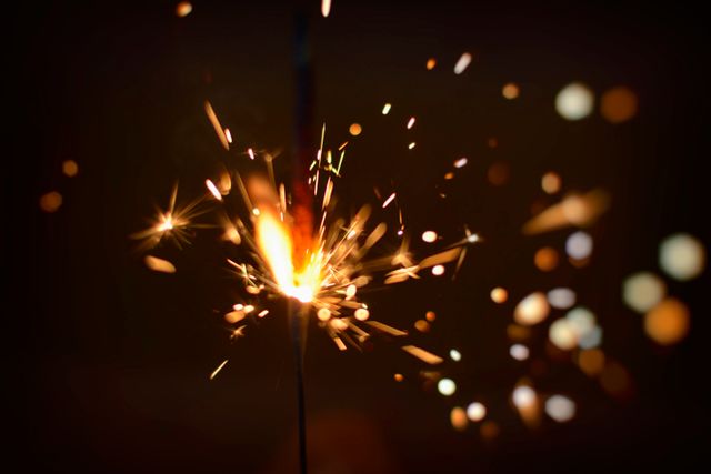 Capturing the vibrant energy of a sparkler burning brightly against a dark background. Perfect for use in designs and materials related to celebrations, parties, festivities, New Year's Eve, weddings, and other joyous events.