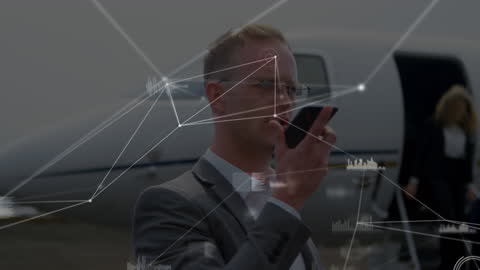 Businessman Communicating with Smartphone and Digital Graphics