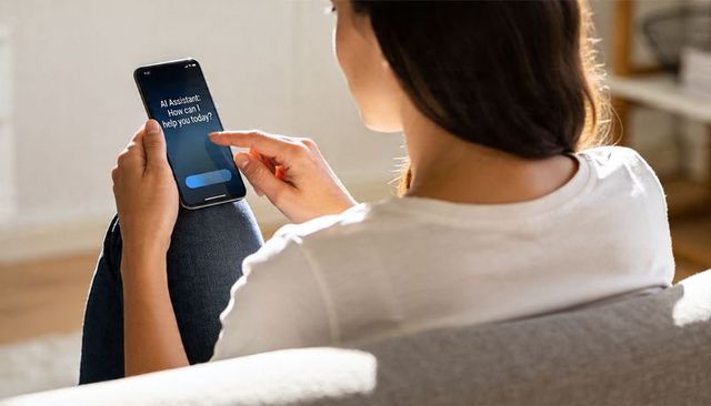 Woman tapping smartphone showing ai assistant prompt while relaxing on sunlit couch