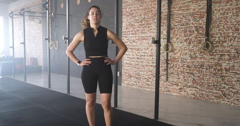 Confident Woman in Gym with Rings and Workout Gear