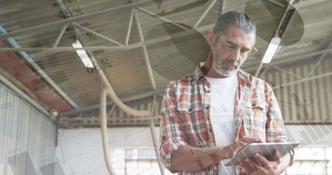 Senior Man Analyzing Business Data on Tablet in Warehouse